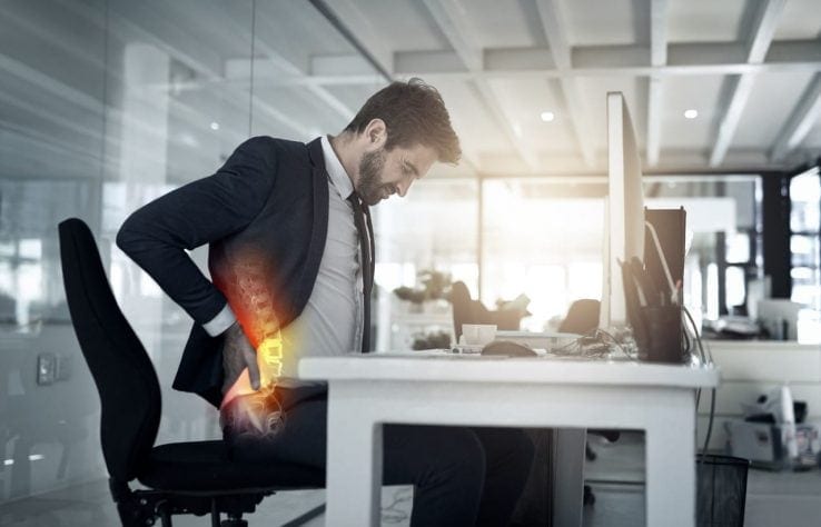 A diagram showing how a mans spine looks while he is sitting at his office desk