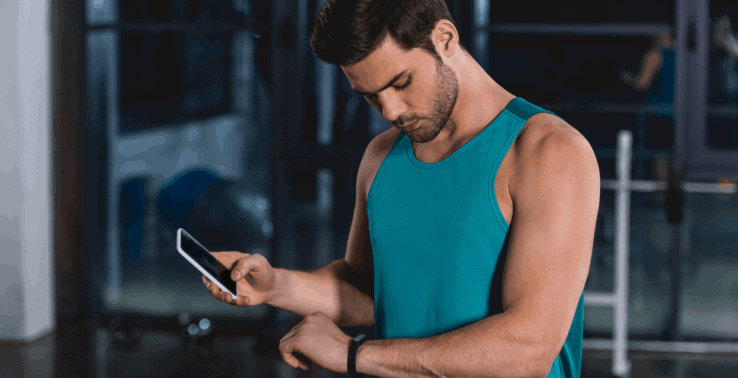 A man checking the progress of his fitness tracker on his mobile phone