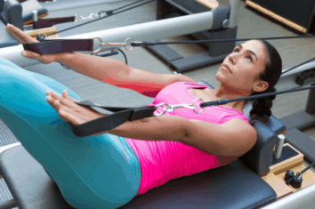 A woman using a reformer pilates machine