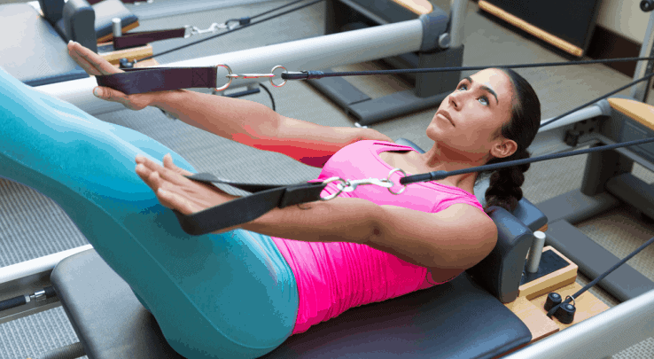 A woman using a reformer pilates machine