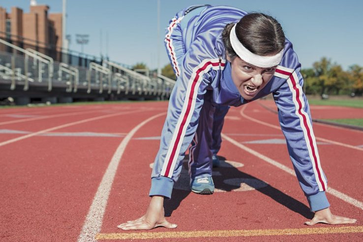 A woman looking very determined while waiting at the start line of a race