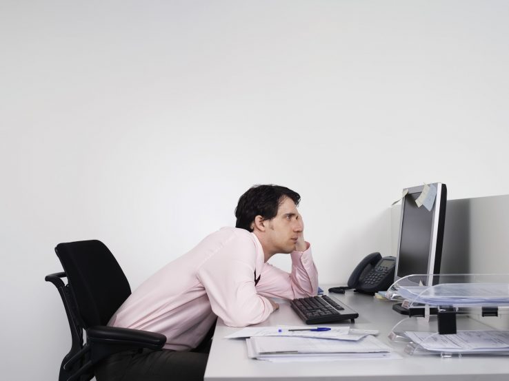 A man slouching at his office desk