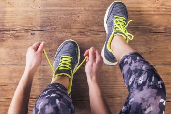 A close up of a woman typing up her running shoes