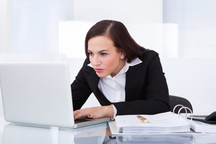 A businesswoman slouching over her desk