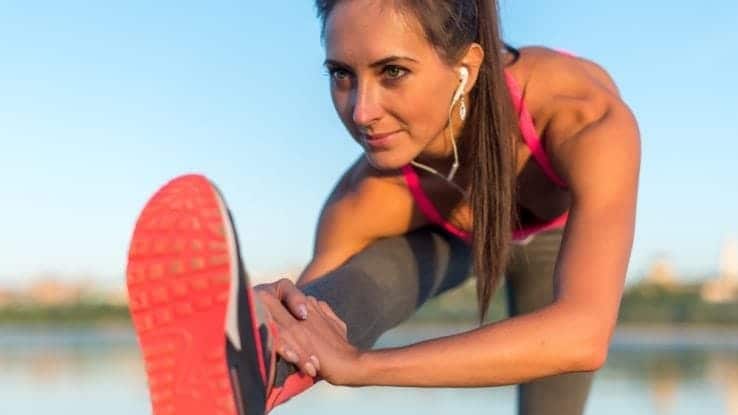 A close up of a female runner stretching out her hamstrings