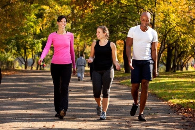 A group of men and women walking through the park