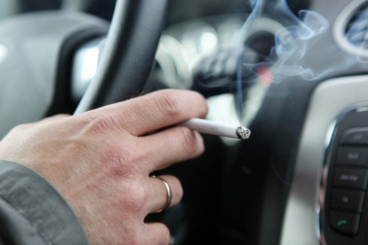 A man in his car smoking