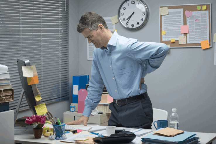 A man in his office having problems with his lower back