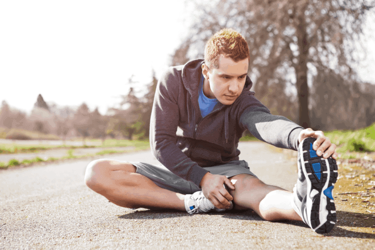 A man sat down while stretching out his leg
