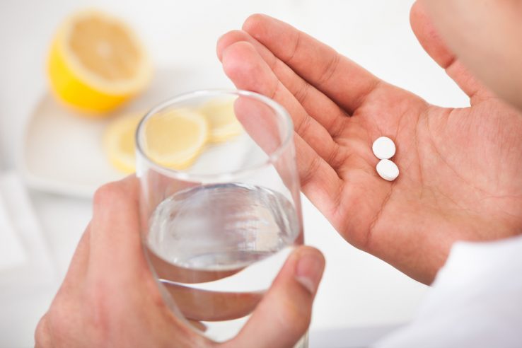 A man taking tablets for his bad back