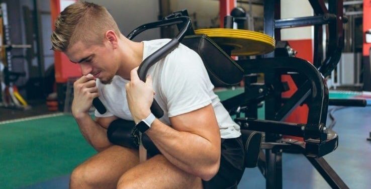 A man using an ab crunch machine in the gym