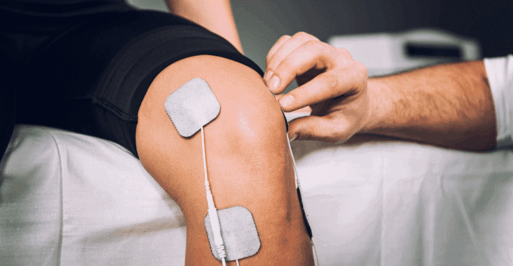 A man using muscle stimulators to treat his knee pain
