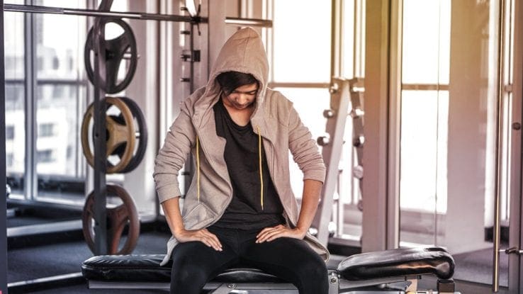 A tired woman in the gym resting after too much exercise