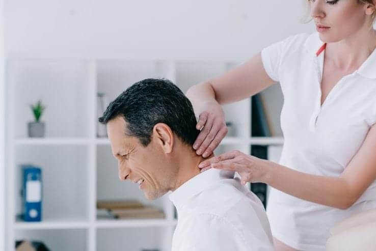 A woman massaging the neck of a man