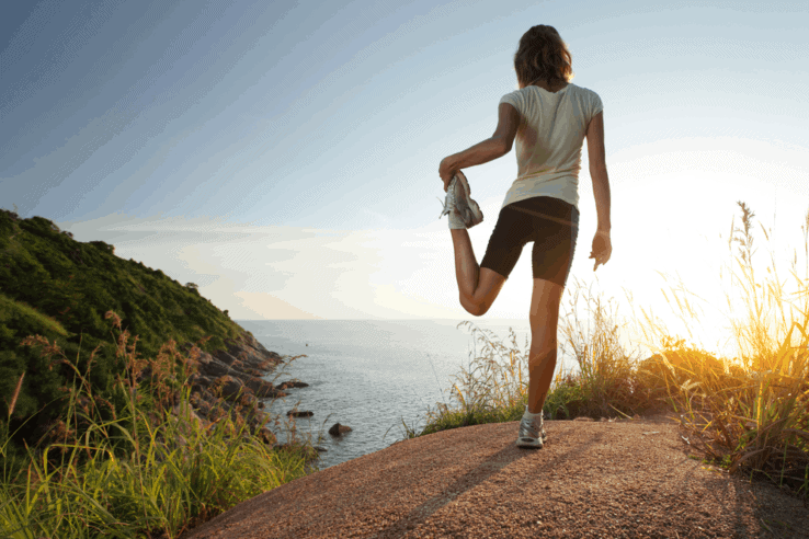 A woman stretching her quads after a long run