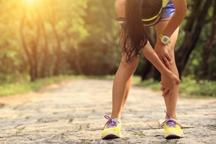 A woman suffering with shin splints while she is running