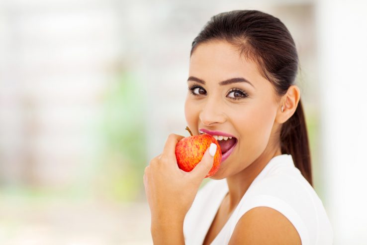 A young woman eating an apple
