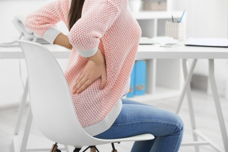 A young woman stretching out her lower back