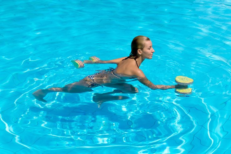 A young woman using weights during a aqua therapy class