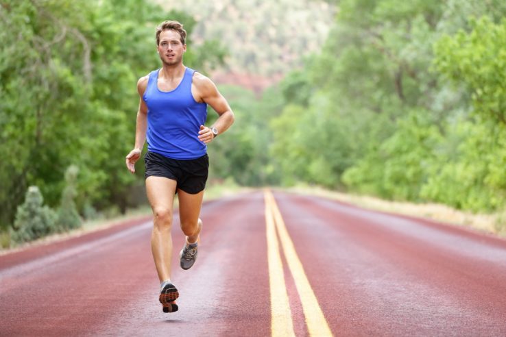 An athletic man running down the road