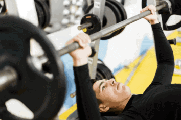 An average build man bench pressing in the gym