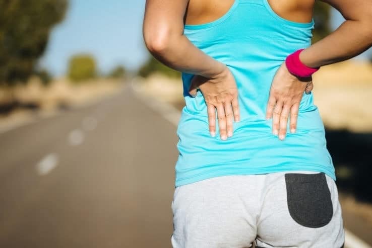 Female runner having problems with the middle of her back