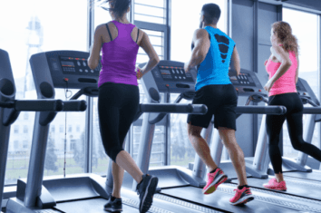 Multiple people running on treadmills side by side