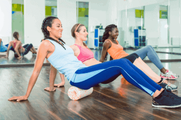 Beautiful women doing exercising on versatile foam roller