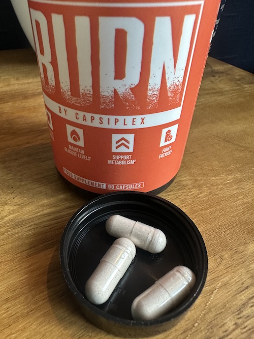 Burn by Capsiplex capsules in bottle lid next to bottle