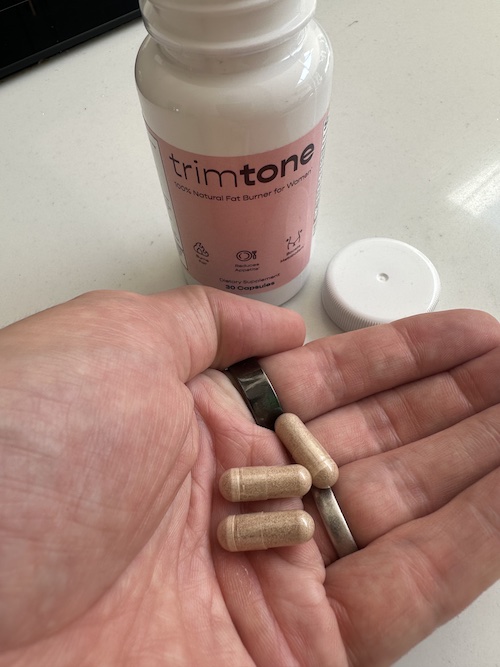 Trimtone capsules in hand next to bottle