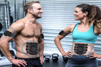 a couple using ab stimulators while training in the gym