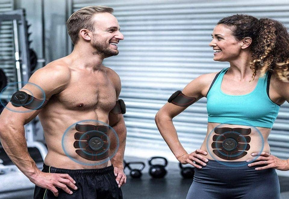 a couple using ab stimulators while training in the gym