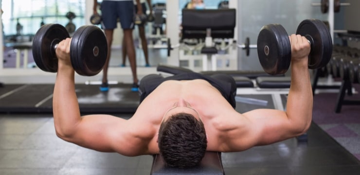 a man doing chest press, with dumbbells