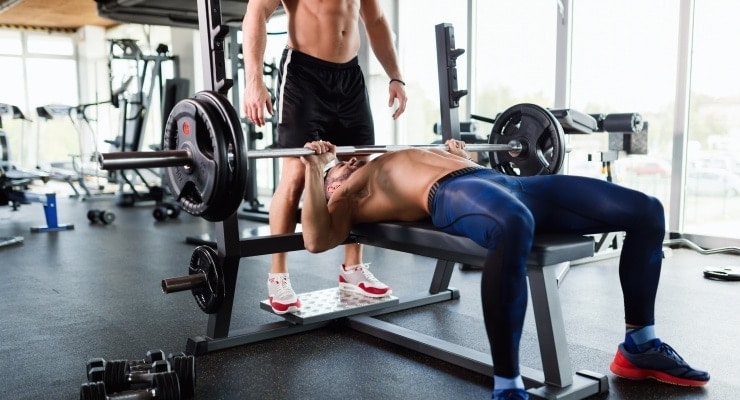 a man exercising in the gym with a bench press