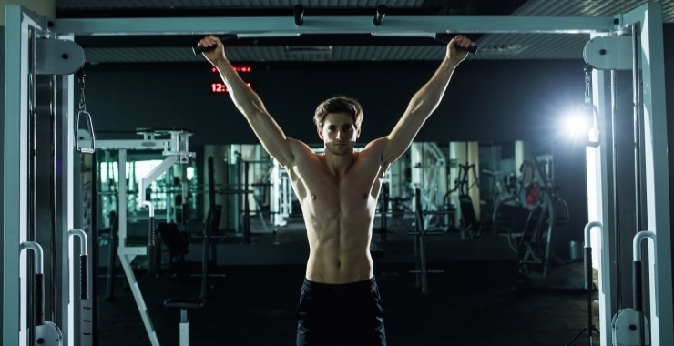 a man exercising in the gym with pull ups