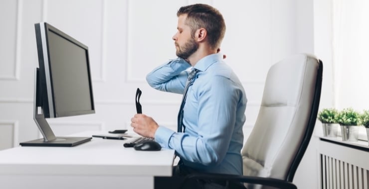a man sitting in a chair rubbing his neck because of his bad posture