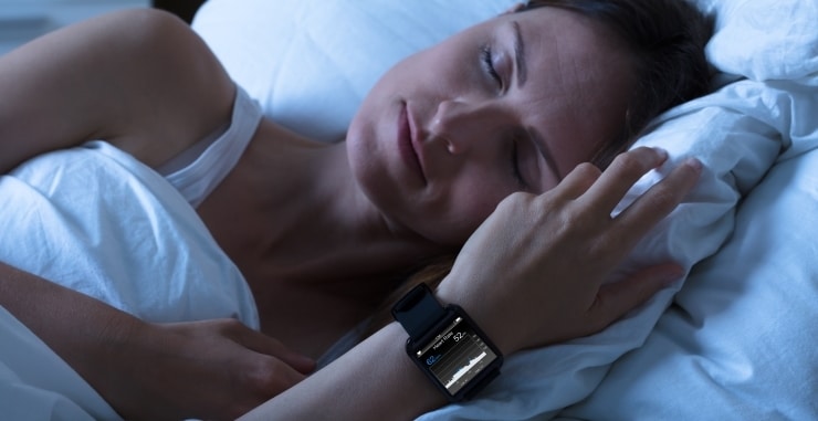 a woman sleeping wearing a fitness tracker