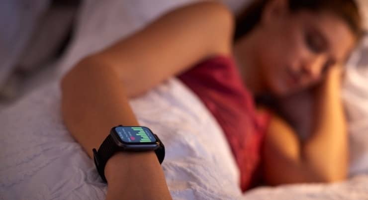 a woman sleeping with a fitness tracker