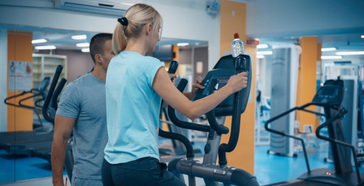 a woman using an elliptical machine at the gym