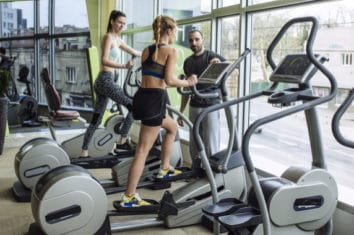 two women working out on elliptical machines