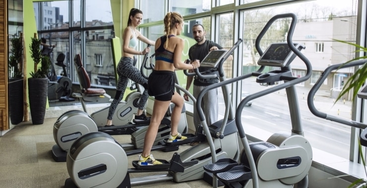 two women working out on elliptical machines
